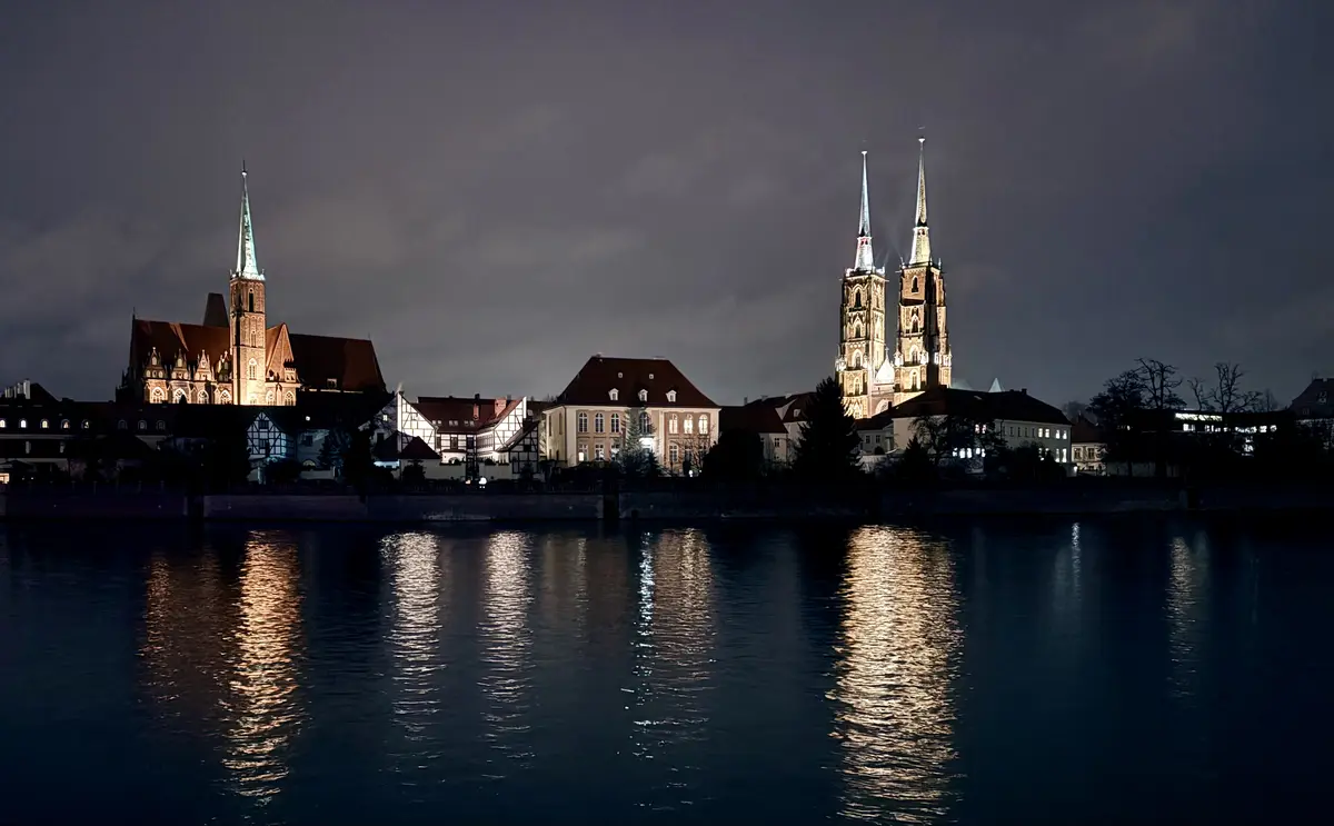 Ostrów Tumski und die beleuchtete Kathedrale bei Nacht, gesehen über die Oder