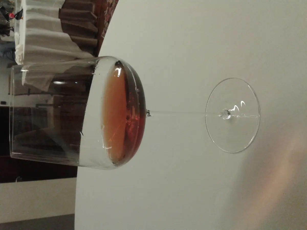 Orange Wine im Glas mit warmem Licht im Hintergrund